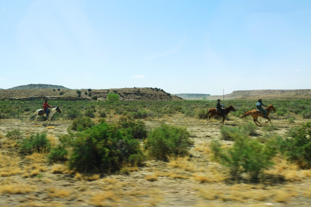 Drei Cowboys reiten durch die Landschaft